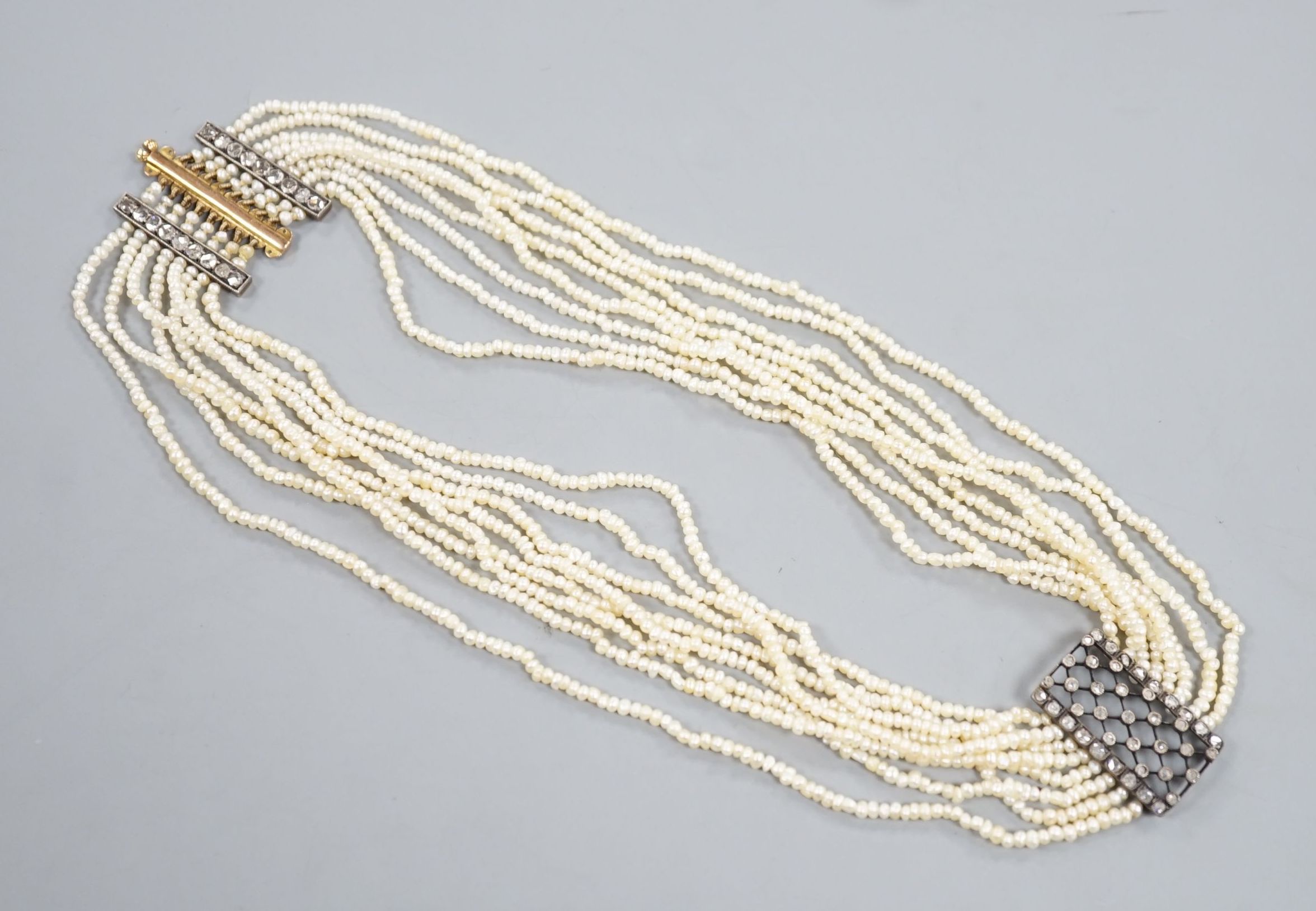 A 19th century multi-strand seed pearl choker necklace with yellow metal and rose cut diamond set clasp and trellis motif, approx. 40cm, gross weight 31.1 grams.